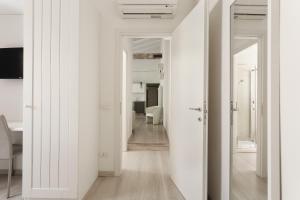 a room with white walls and a hallway with a door at Opera Residence in Bologna +141 photos