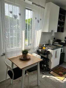 eine Küche mit einem Tisch, Stühlen und Fenstern in der Unterkunft Ca Rota house free parking in Lipomo