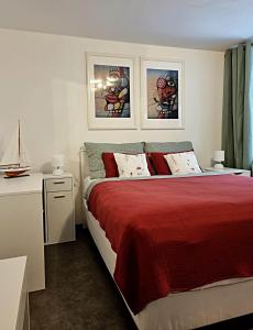 - une chambre avec un lit et une couverture rouge dans l'établissement Apartmán Zlatý kříž, à Písek