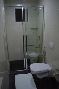 uma casa de banho com um WC e uma cabina de duche em vidro. em Hotel Diamonds Pearl em Visakhapatnam