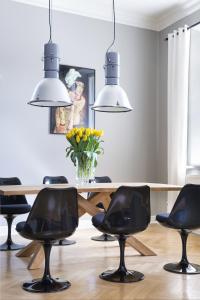a dining room with a table and black chairs at Apartments Rynek Glowny in Krakow