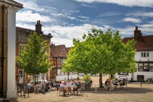 a group of people sitting at tables in a courtyard at West Street Loft in Midhurst