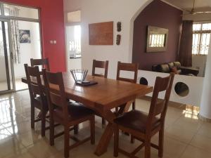 uma sala de jantar com uma mesa de madeira e cadeiras em Accra Service villas - villa 2? em Spintex