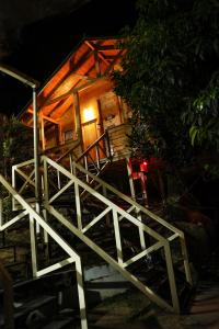a wooden cabin with a staircase leading to the door at Woodrose Resort in Kalpetta