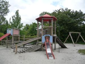 einen Spielplatz mit Rutsche im Sand in der Unterkunft CHALET36 in GROU in Grou