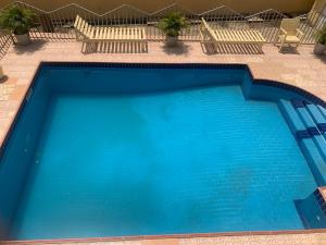 a large blue swimming pool with two chairs and a bench at Accra Service villas - villa 2? in Spintex