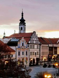 un grand bâtiment avec une tour d'horloge en haut dans l'établissement Apartmán Zlatý kříž, à Písek