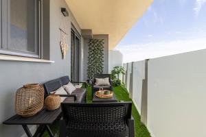 a patio with chairs and a table on a balcony at Allo Apartments Bonald Piscina - Parking 3 Habitaciones in Jerez de la Frontera