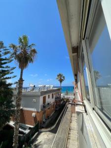 einen Blick auf das Meer von einem Gebäude mit einer Palme in der Unterkunft Emma's House in Cefalú