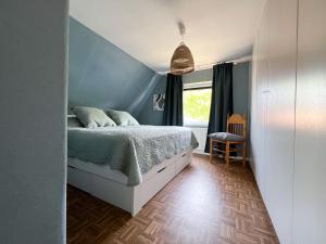 um quarto com uma cama e uma parede azul em "Ohuus" Ferienhaus mit Garten em Büsum