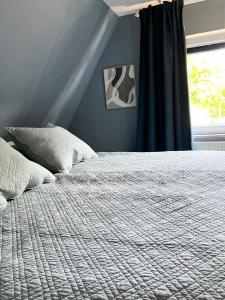 a bedroom with a bed with a blue wall and a window at "Ohuus" Ferienhaus mit Garten in Büsum