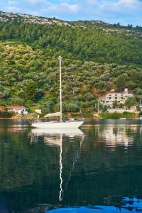 a sailboat sitting on the water in a lake at Chronos Hotel in Porto Koufo