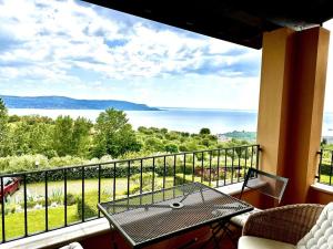d'un balcon avec une table et une vue sur l'eau. dans l'établissement Casa Giulia: un'oasi di pace, à Toscolano Maderno