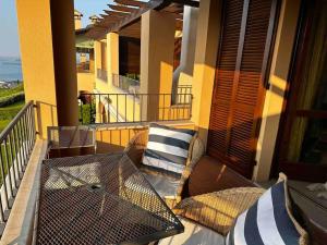 d'une terrasse avec une table et des oreillers sur un balcon. dans l'établissement Casa Giulia: un'oasi di pace, à Toscolano Maderno