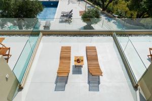 an overhead view of a patio with benches and a table at Chronos Hotel in Porto Koufo