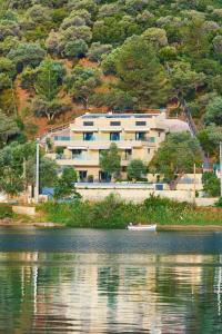a large building on the side of a lake at Chronos Hotel in Porto Koufo