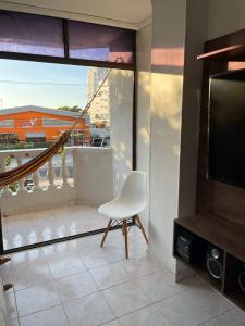 un soggiorno con sedia bianca e una grande finestra di apartamento Santa Marta-Rodadero Blanquita205 a Santa Marta