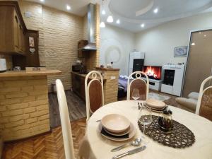 un salon avec une table et une cuisine avec une cheminée dans l'établissement Aurora apartment Novi Sad, à Novi Sad