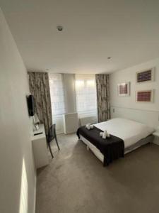 a bedroom with a bed and a tv in it at Residence OLit Cathédrale in Strasbourg