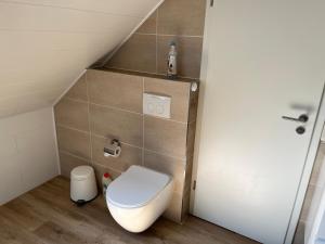 a small bathroom with a toilet and a staircase at Apartment Topp adult only in Wangerland