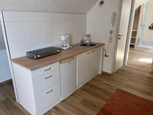 a small kitchen with a counter and a sink at Apartment Topp adult only in Wangerland