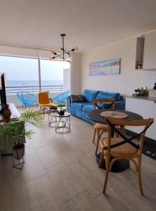 ein Wohnzimmer mit einem blauen Sofa und einem Tisch in der Unterkunft Departamento en Antofagasta 2D+1B FULL in Antofagasta