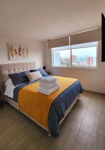 1 dormitorio con 1 cama grande y toallas. en Departamento en Antofagasta 2D+1B FULL en Antofagasta