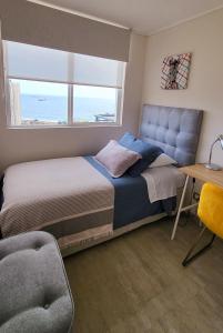 1 dormitorio con cama, escritorio y ventana en Departamento en Antofagasta 2D+1B FULL, en Antofagasta