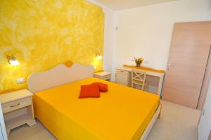 a bedroom with a yellow bed and a desk at B&B Lu Cantoru in Marina di Pescoluse