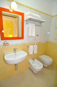 a bathroom with a sink and a toilet and a mirror at B&B Lu Cantoru in Marina di Pescoluse