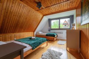 een slaapkamer met 2 bedden en een raam bij Willa Lavinka in Zawoja