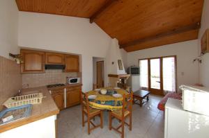 a kitchen and dining room with a table and chairs at Casa Soprana in Porto Pollo