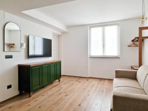 a living room with a television and a couch at Il Caruggio Flat in Varazze +2 photos