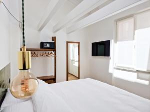 ein weißes Schlafzimmer mit einem weißen Bett und einem Fenster in der Unterkunft Il Caruggio Flat in Varraze
