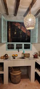 a kitchen with a sink and baskets and a chandelier at Yasmin house in Kizimkazi