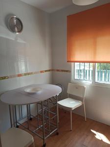 uma pequena cozinha com uma mesa e uma cadeira em MIS NIÑAS em Conil de la Frontera