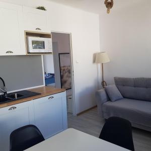 a living room with a couch and a tv in it at Apartament 3 pokoje z balkonem Asklepios in Świnoujście