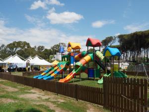 a park with a playground with a colorful slide at Camping Village Mare Pineta in Paestum