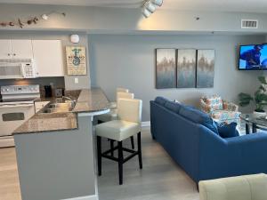 a kitchen and living room with a blue couch and a counter at Shores of Panama Condo With Same Level Parking in Panama City Beach