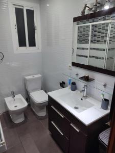 a white bathroom with a toilet and a sink at Bedroom to rent in the beach in Valencia