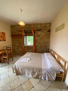 a bedroom with a bed and a stone wall at Affittacamere Porta Majella in San Valentino in Abruzzo Citeriore