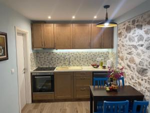 een keuken met houten kasten en een tafel met stoelen bij Filipa Apartment in Limenas +8 foto's