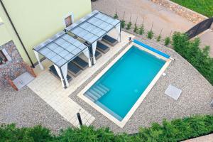 an overhead view of a swimming pool with a table and chairs at Holiday house Toš-Vila with heated pool in Vrbnik