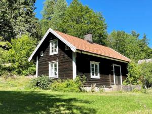 a small black house with a red roof at Cozy holiday home in Tranas, Odeshog in Tranås
