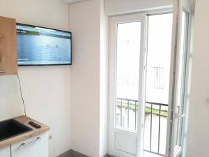 een keuken met een tv aan de muur naast een raam bij studio hyper-centre confortable acces boite a clee parking in Castres