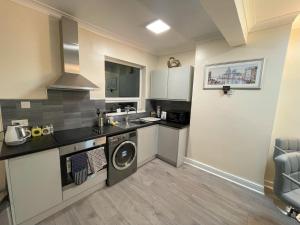 y cocina con lavadora, fregadero y lavadora. en 2 Bed 1st Floor Flat near Centre, en Nottingham