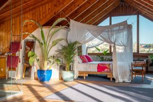 a bedroom with a canopy bed and potted plants at BARCELONA´S TROPICAL OASIS in Sant Just Desvern