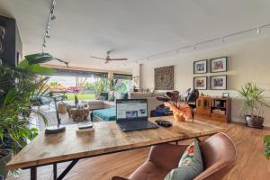 ein Wohnzimmer mit einem Tisch und einem Laptop darauf in der Unterkunft BARCELONA´S TROPICAL OASIS in Sant Just Desvern