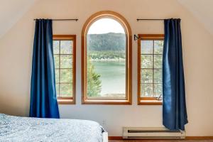 a bedroom with a window with a view of a lake at Juneau Vacation Home Stunning View and Beach Access in Mendenhaven