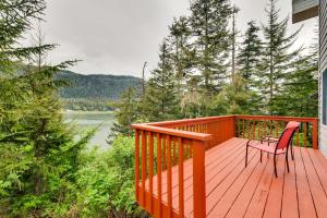 a wooden deck with a chair and a table on it at Juneau Vacation Home Stunning View and Beach Access in Mendenhaven